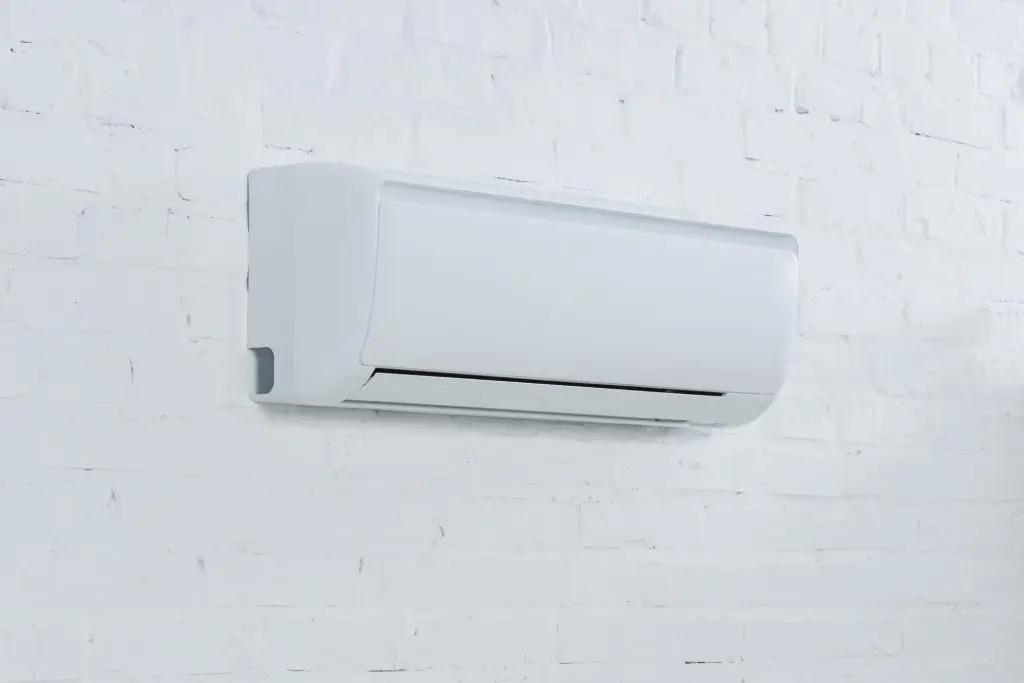 close-up shot of air conditioner hanging on brick wall