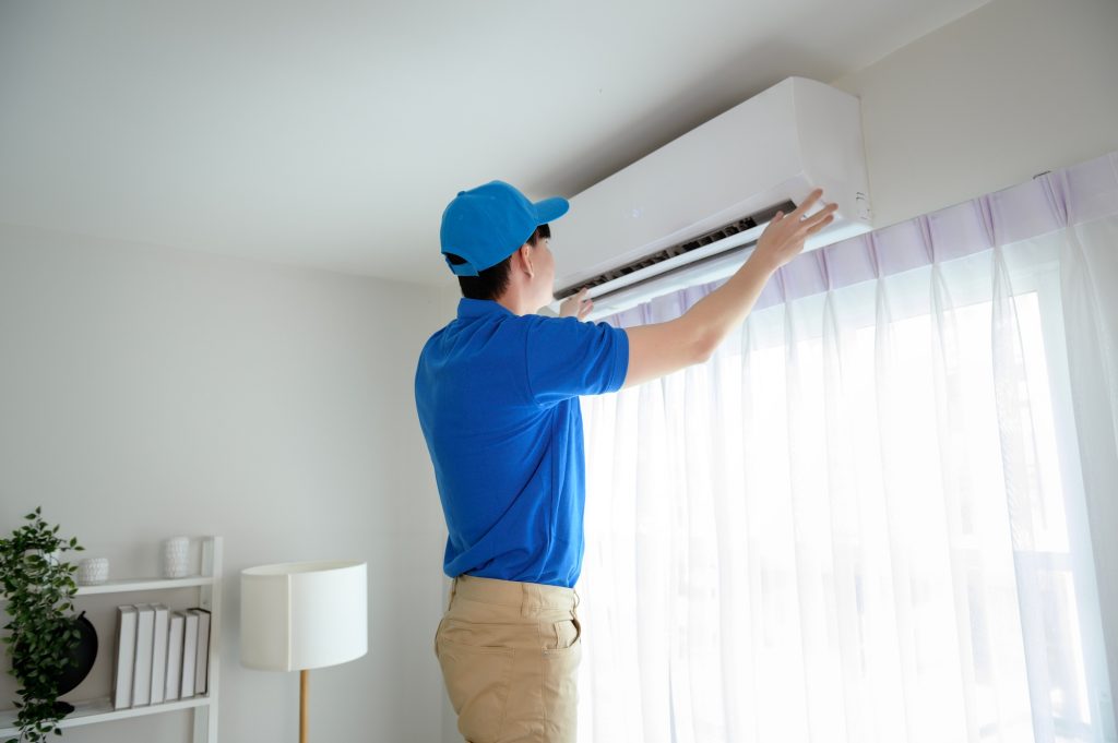 Technician service man checking air conditioner